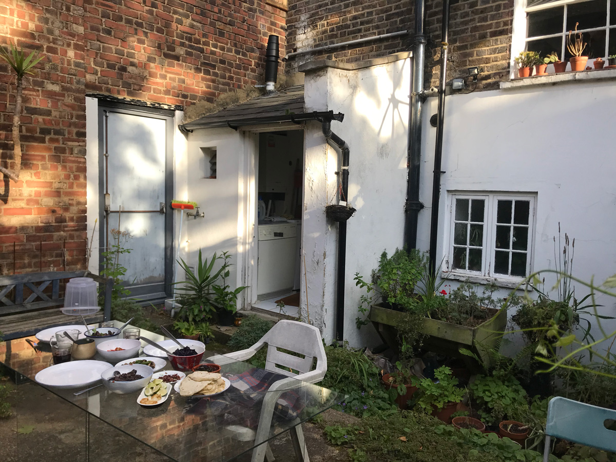 A table laden with food, in a slightly overgrown garden