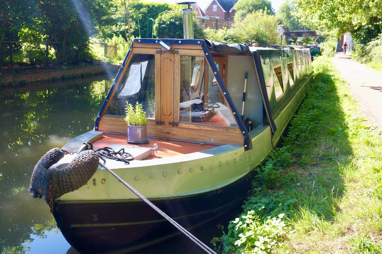 A moored canal boat. The sun is shining and it's mid-summer.