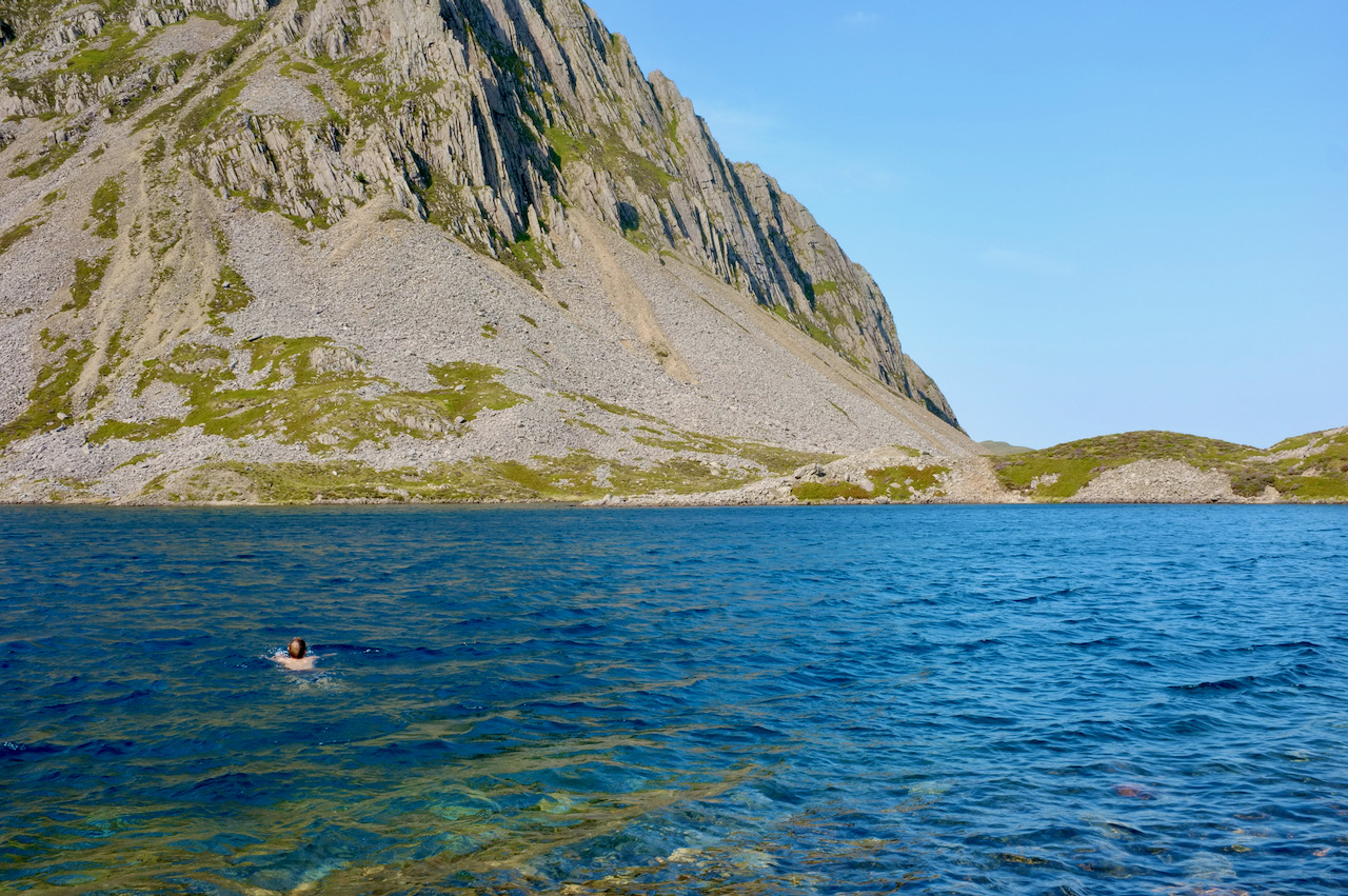 How swimming in a bright blue lake beneath a mountain.