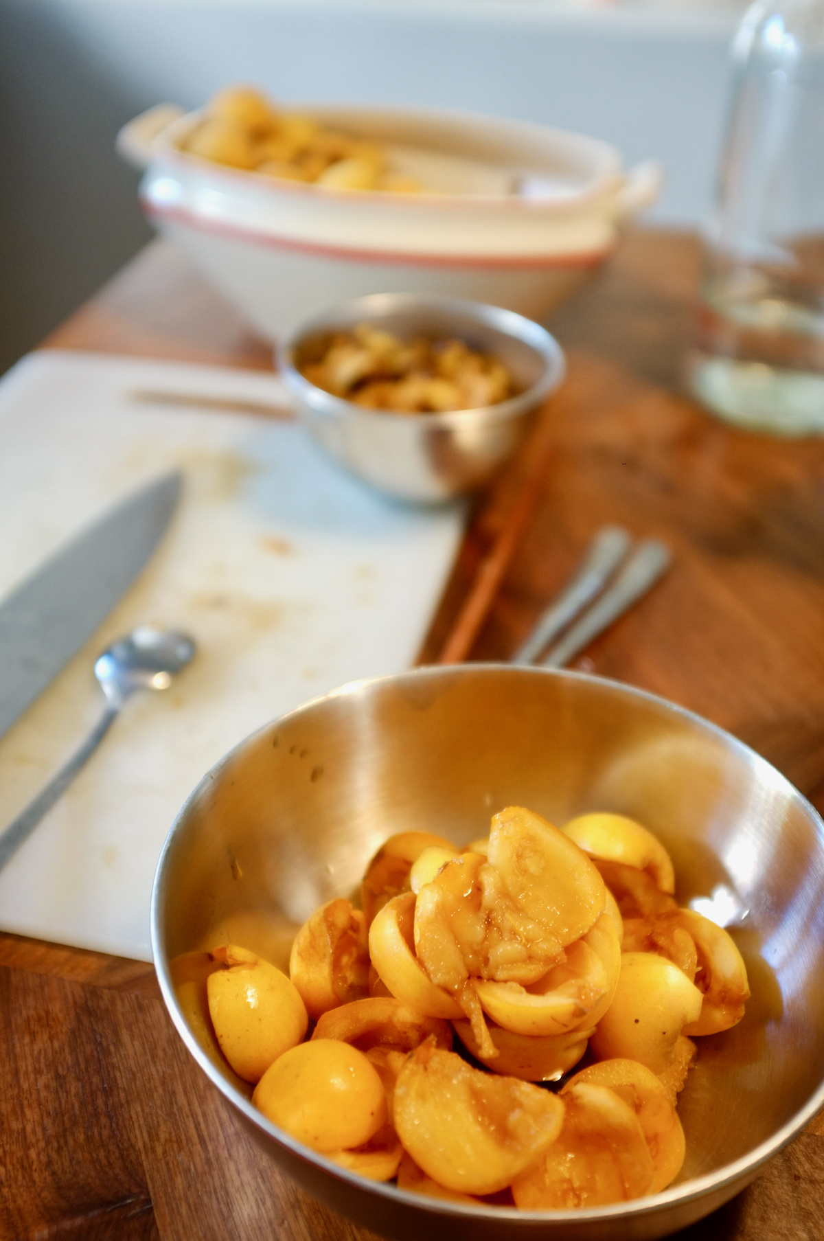 A bowl of quartered orange loquats.