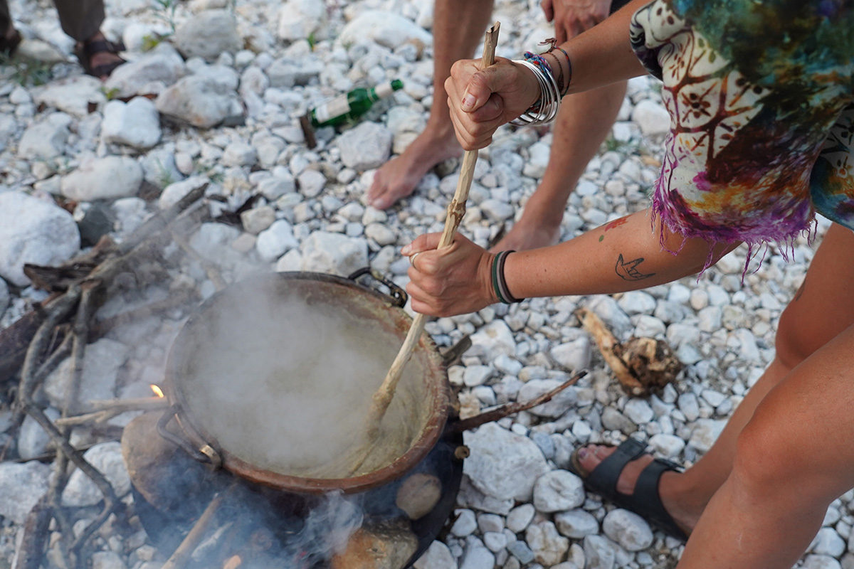 Stirring a big pot of polenta by the riverbank.