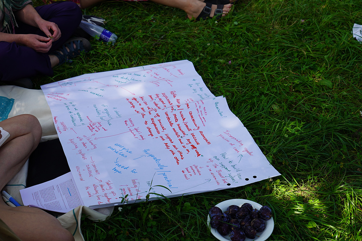 Handwritten notes on a big sheet of paper on the grass.