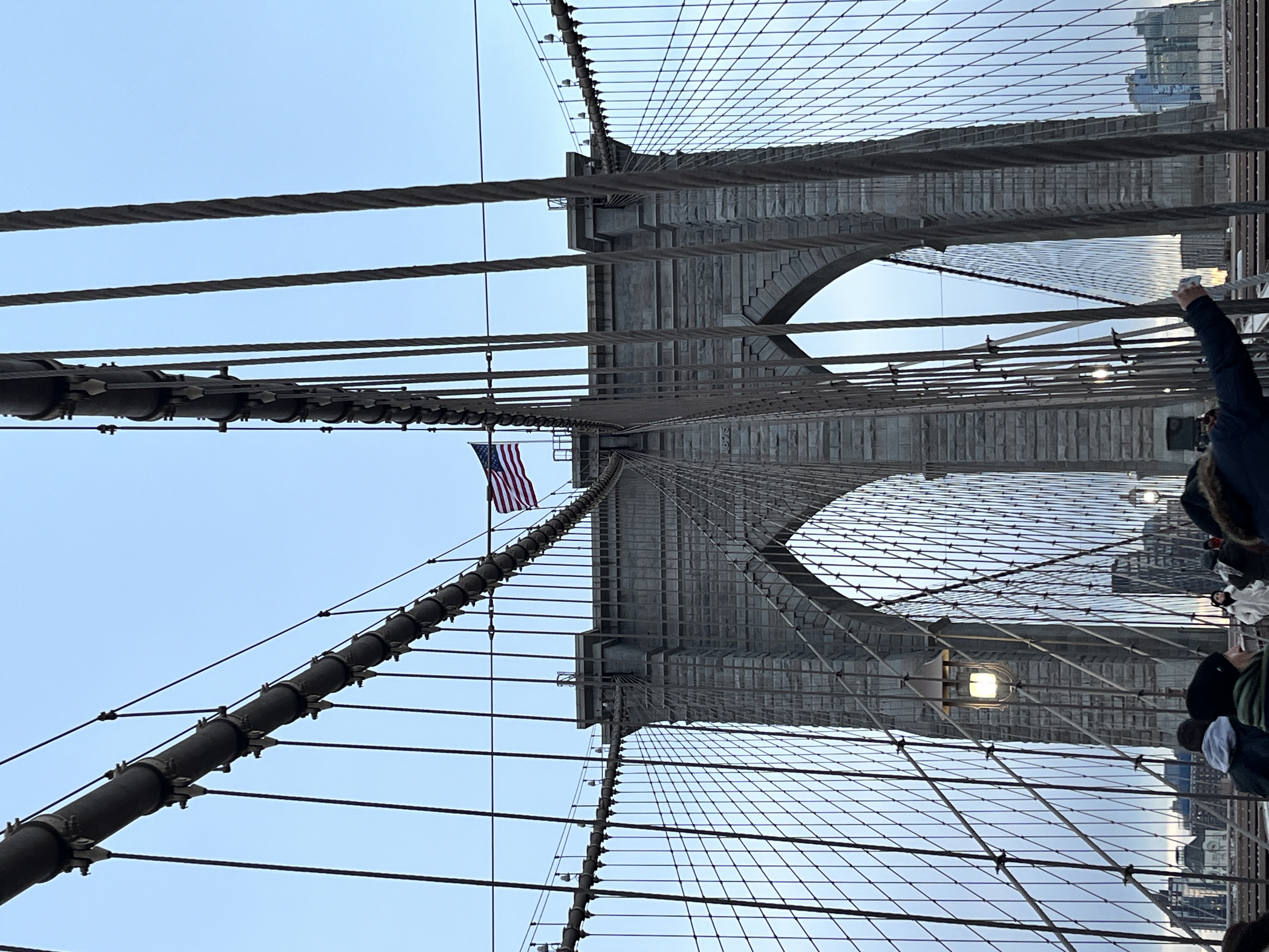 The brooklyn bridge with a USA flag on top
