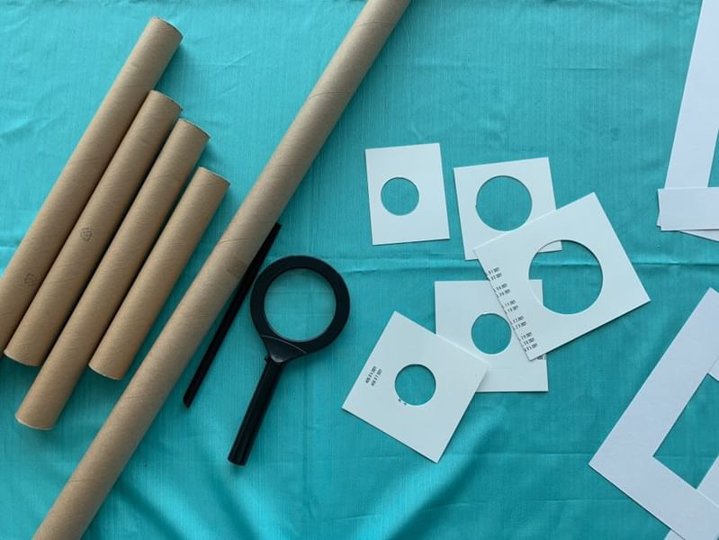 some of the toys we used: cardboard tubes, papers with circles cut out, and magnifying glasses on a turquoise tablecloth