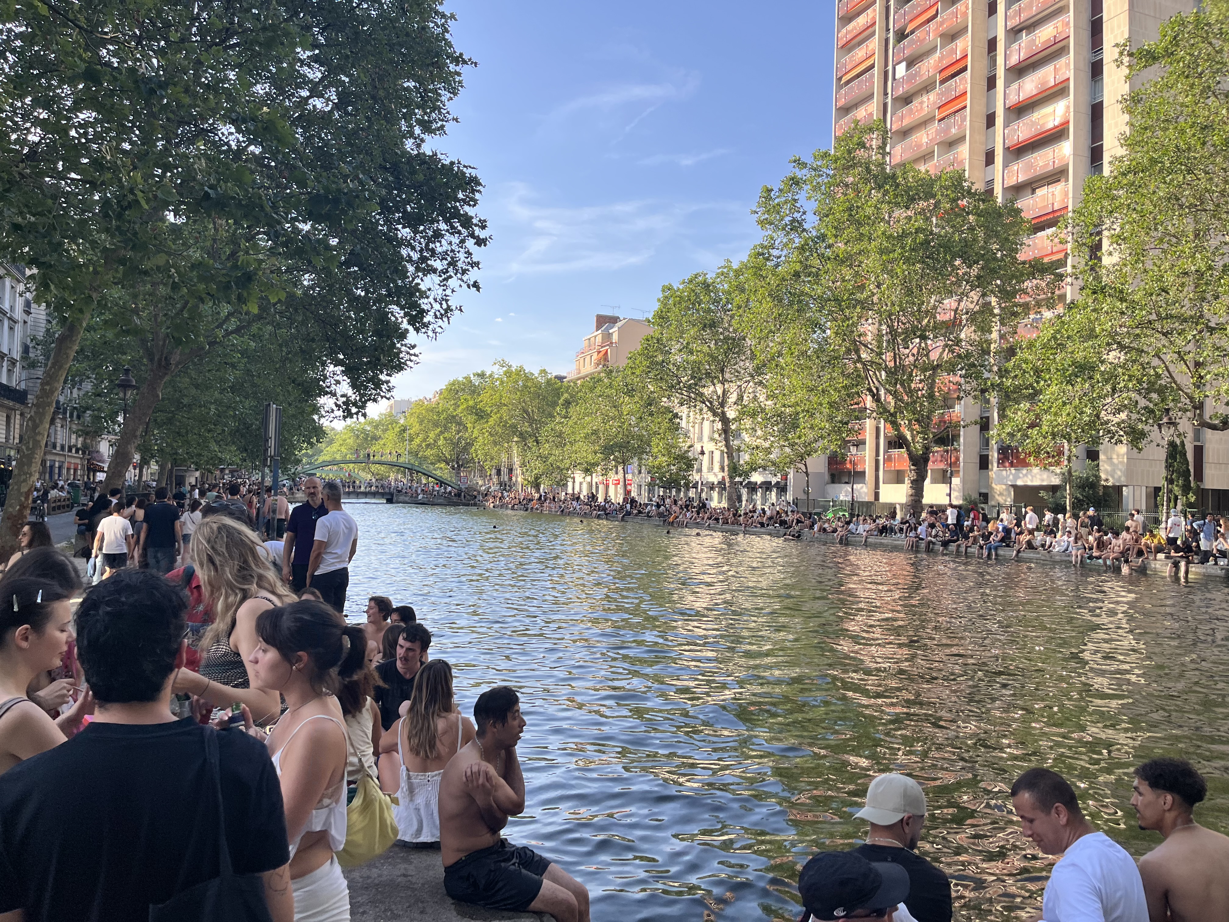 Photo of the Canal Saint-Martin on June 21st, 2026, with bathing crowds around.